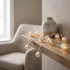 String lights on a wooden surface with a vase in the background