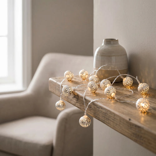 String lights on a wooden surface with a vase in the background