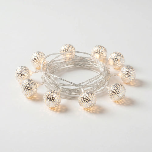 String of decorative lights with metallic bulbs on a light gray background