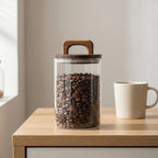 Clear glass kitchen storage jar with natural wood handle lid, front view