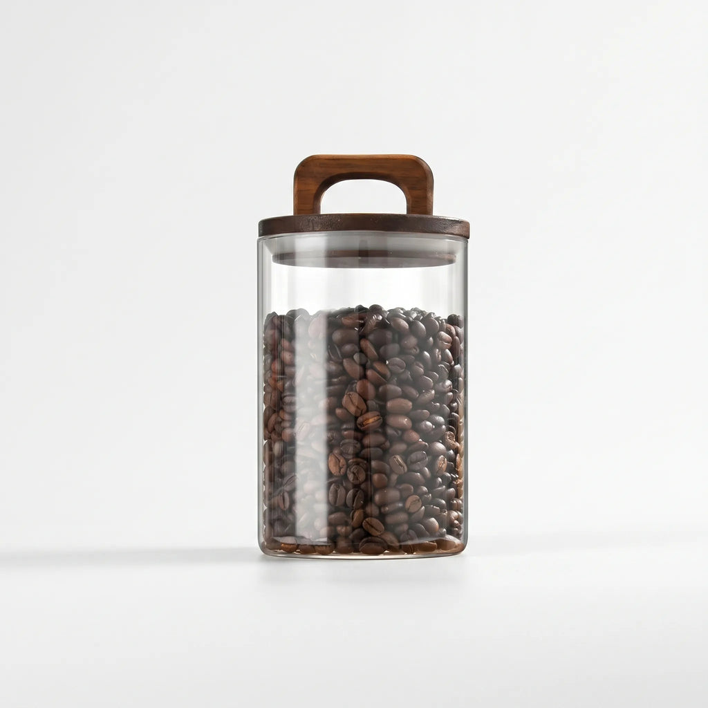 Clear cylindrical glass storage jar with wooden handle lid on white background