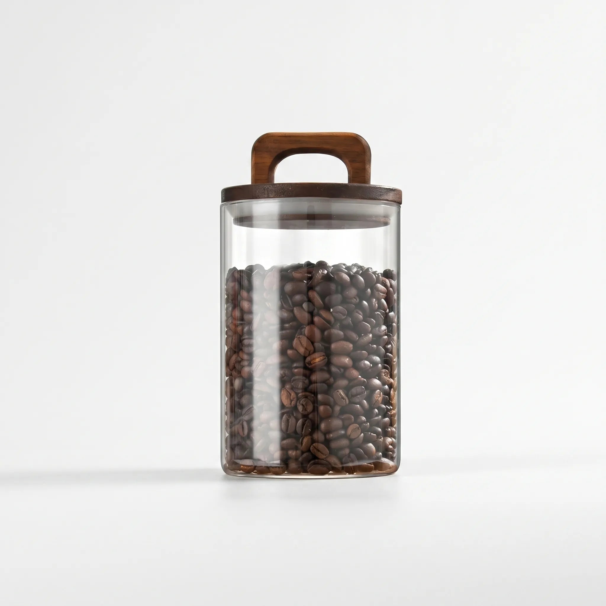 Clear cylindrical glass storage jar with wooden handle lid on white background