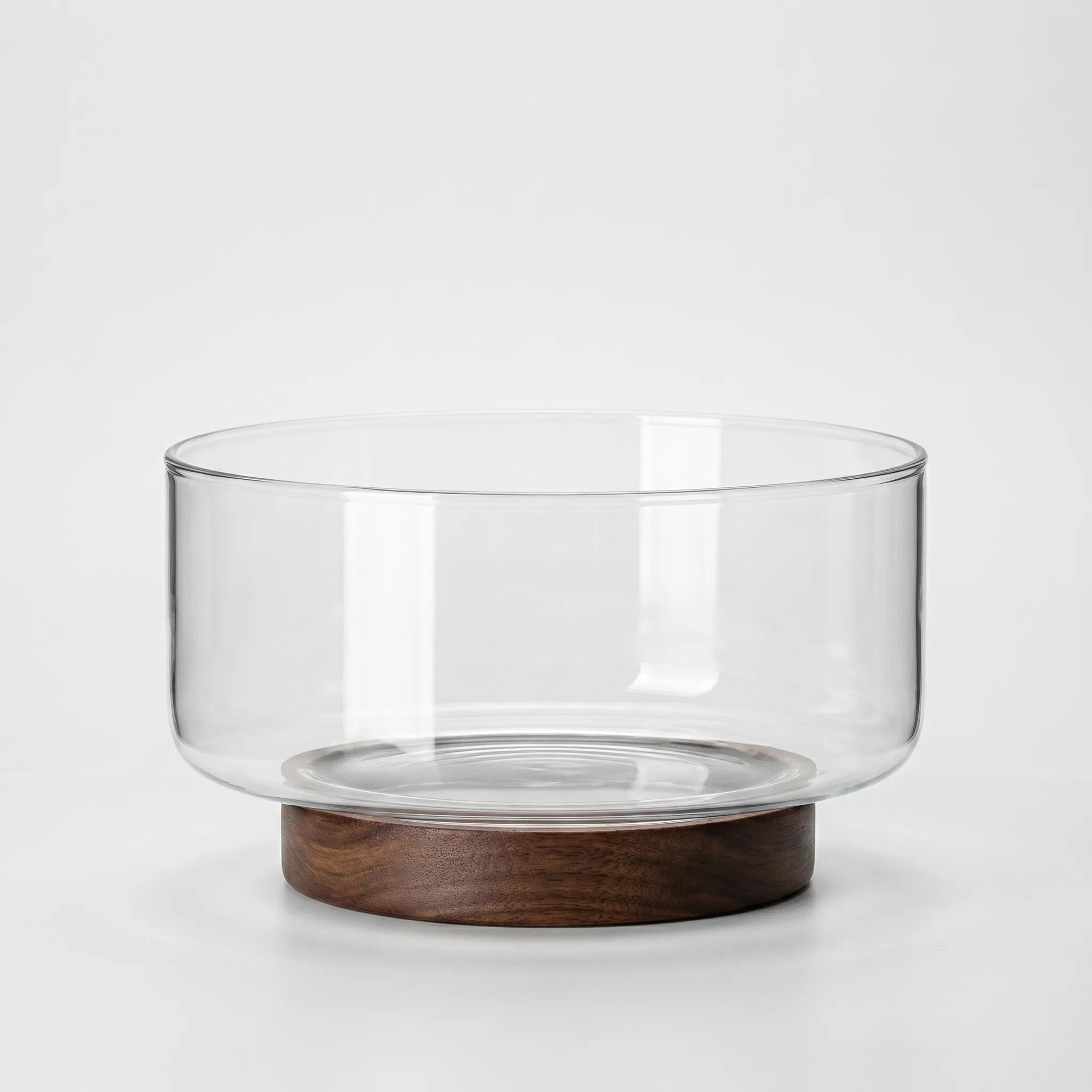 Clear Glass Serving Bowl with Walnut Wood Stand in a nice white studio. 