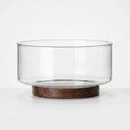 Clear Glass Serving Bowl with Walnut Wood Stand in white studio. 