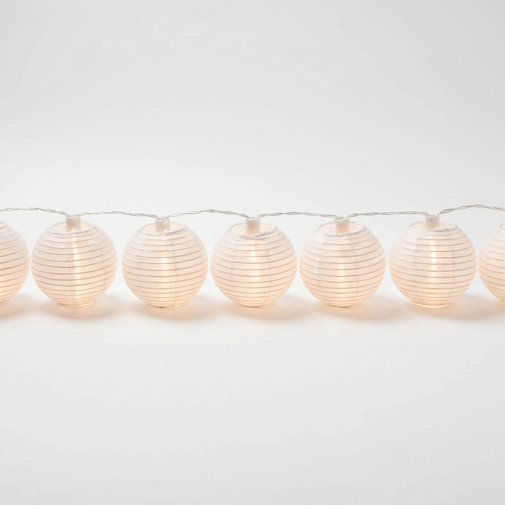 String of white paper lantern lights on a white background