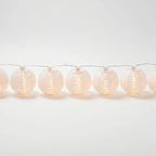String of white paper lantern lights on a white background