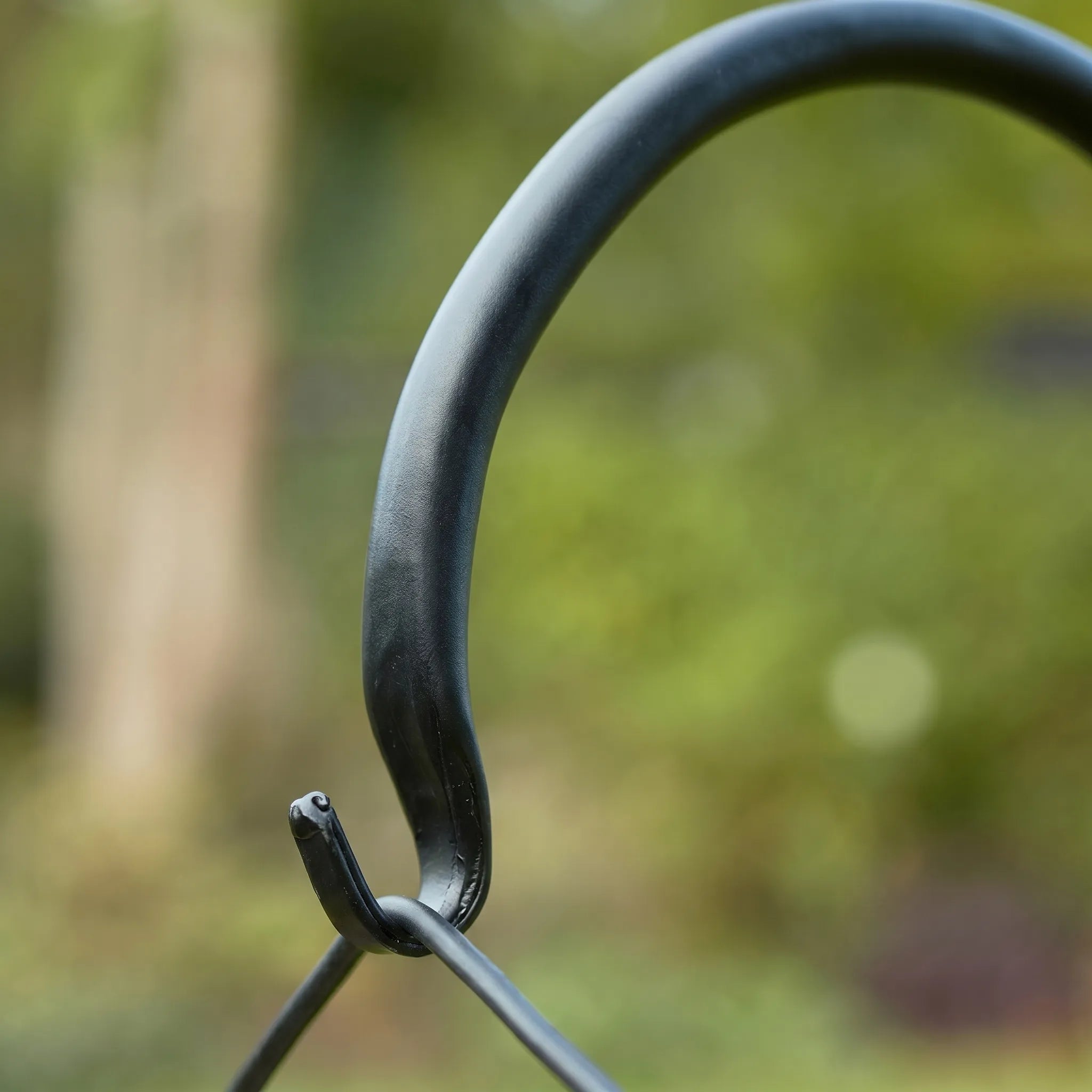 Metal hook against a blurred natural background