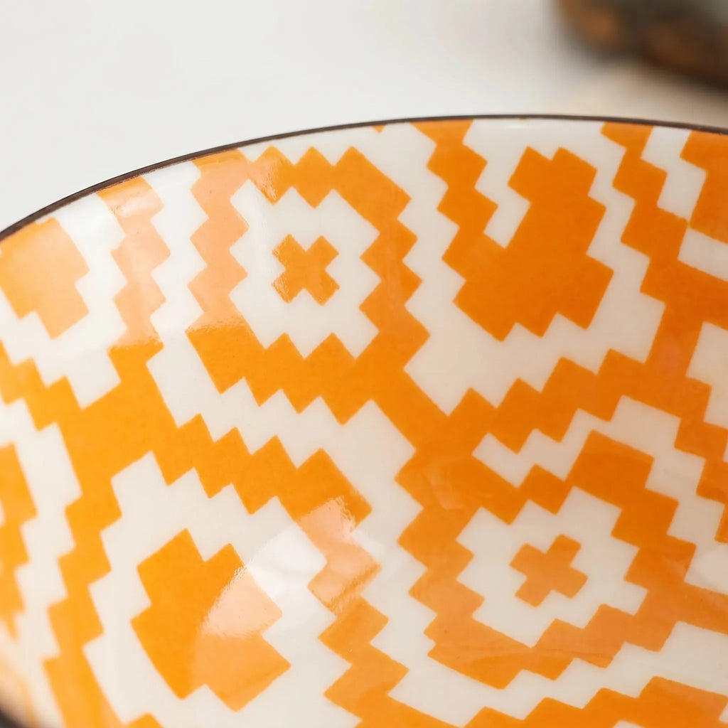 Patterned Ceramic Bowl in orange with a pattern. 