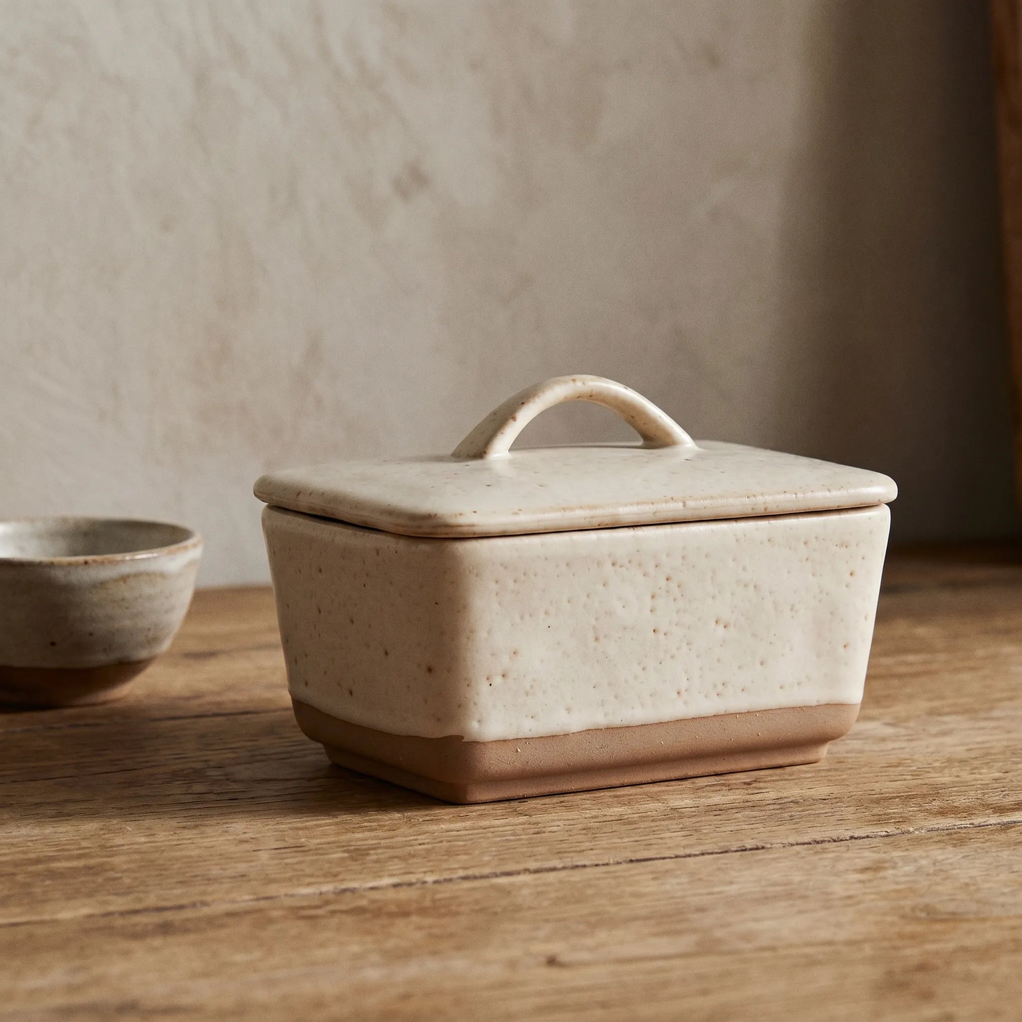 Speckled Stoneware Butter Dish – Cream with Lid on a nice wooden table. 