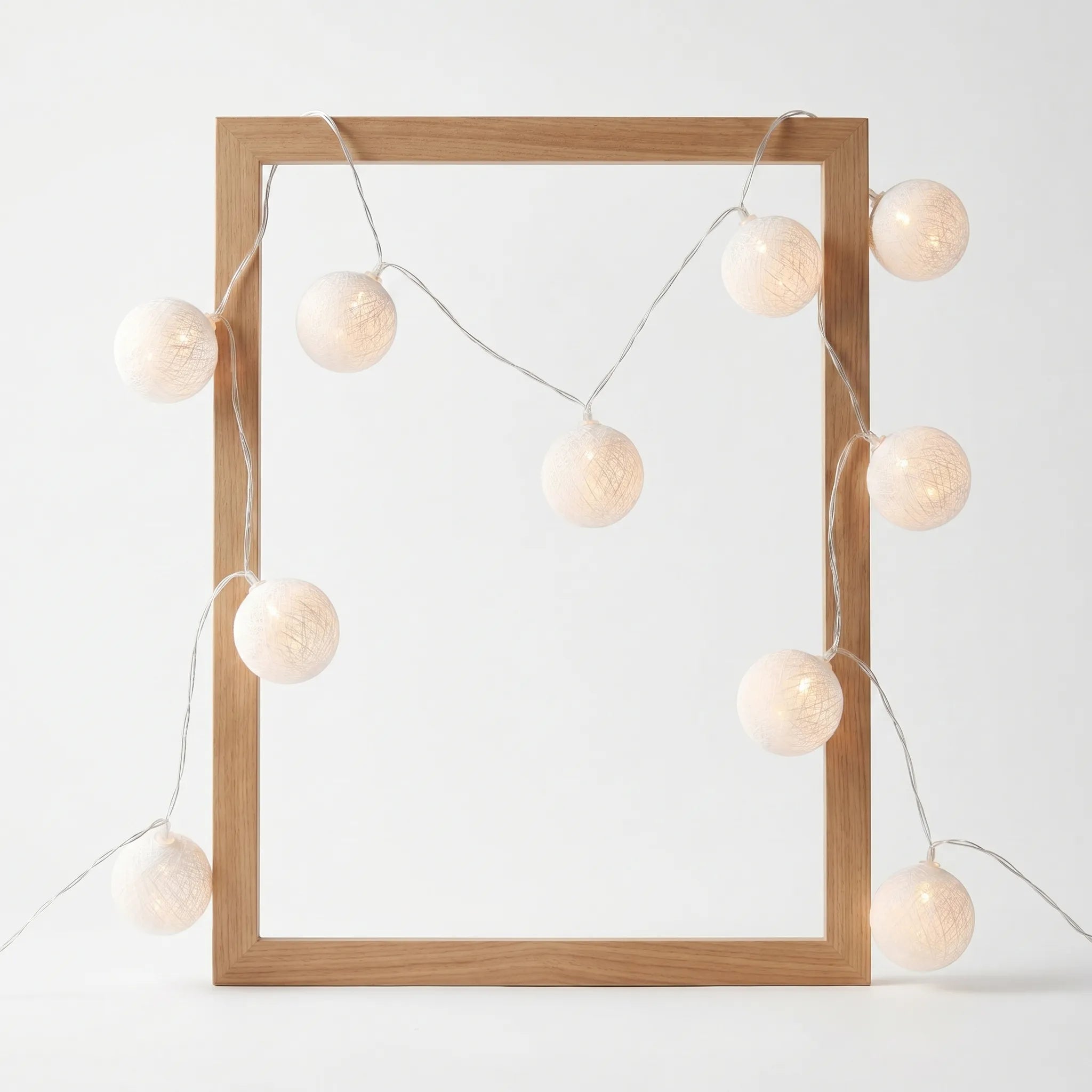 Wooden picture frame with string lights on a white background