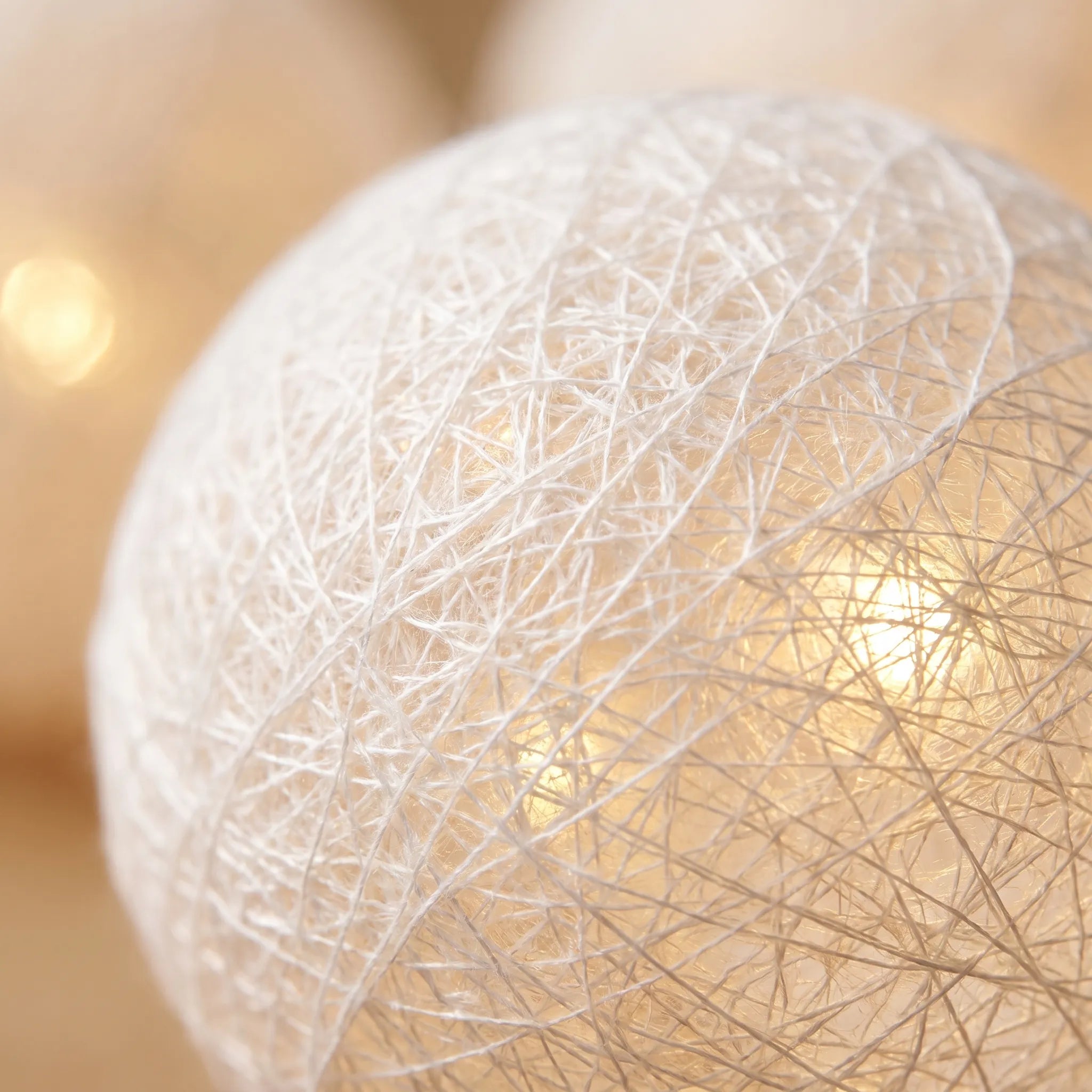 Close-up of a textured white sphere with a blurred warm background