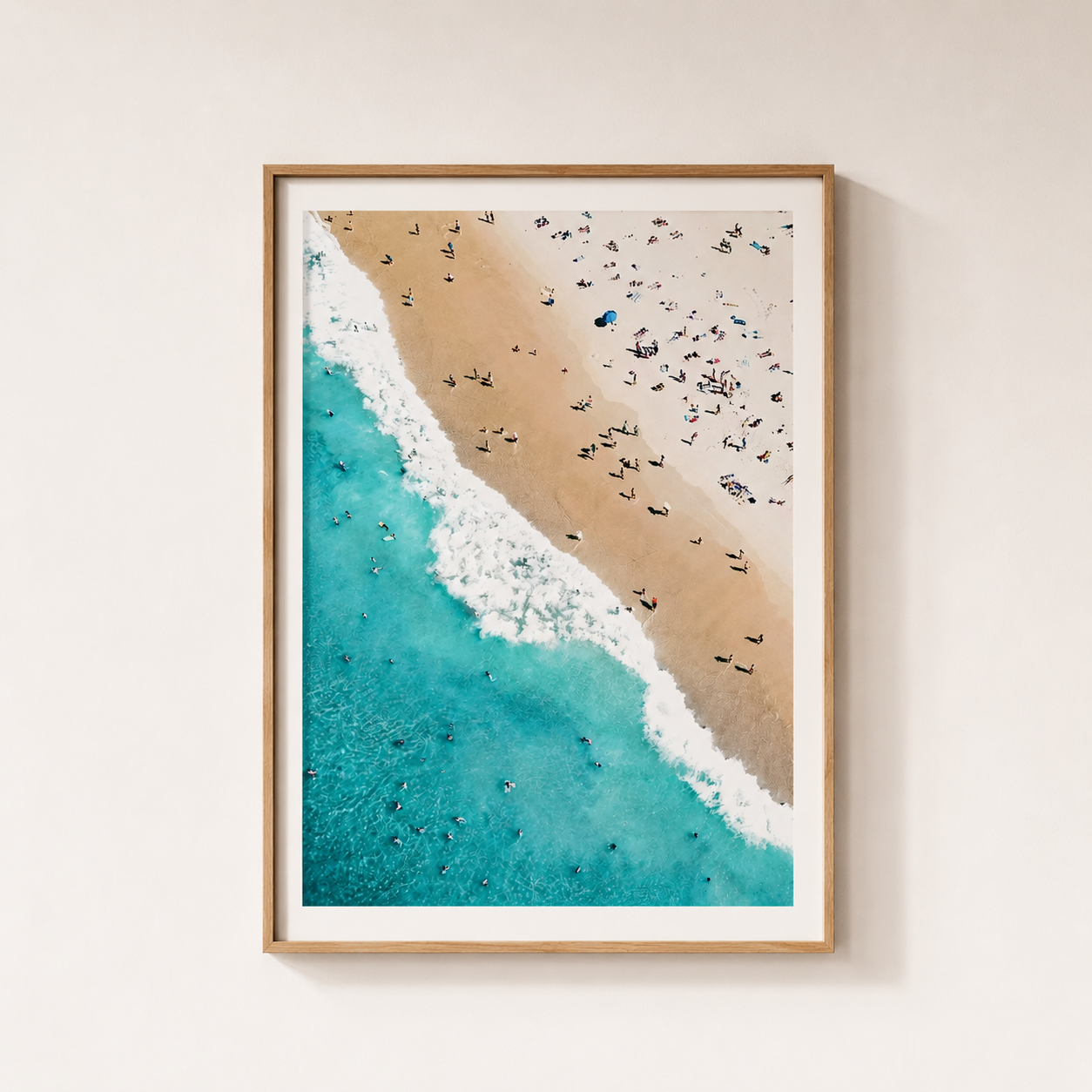 Framed artwork of a beach scene with people and turquoise water.