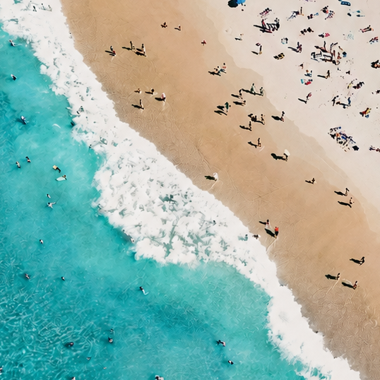 Framed artwork of a beach scene with people and turquoise water.