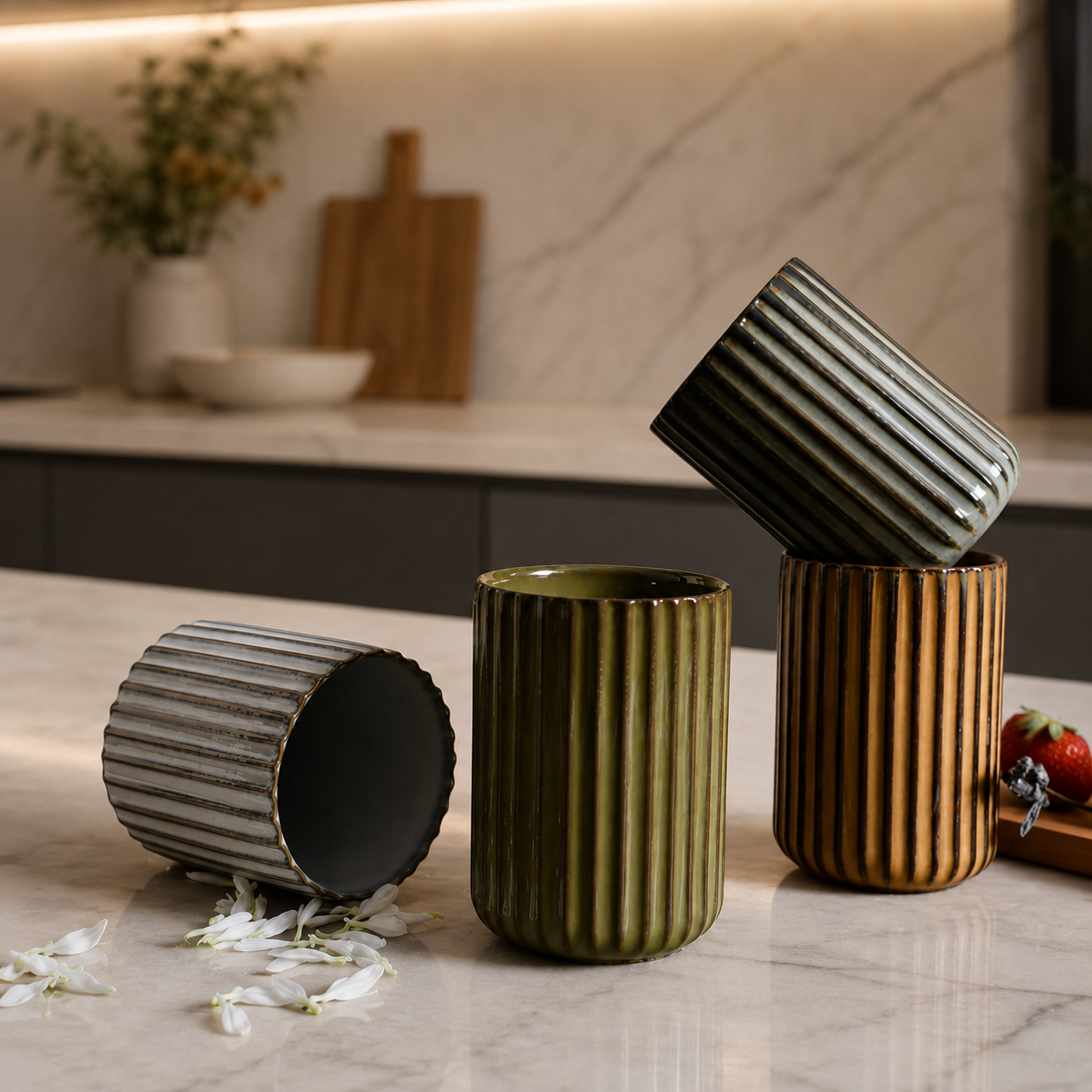 Three ribbed ceramic cups on a kitchen counter with a blurred background