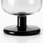 Clear glass bowl with black base on a white background