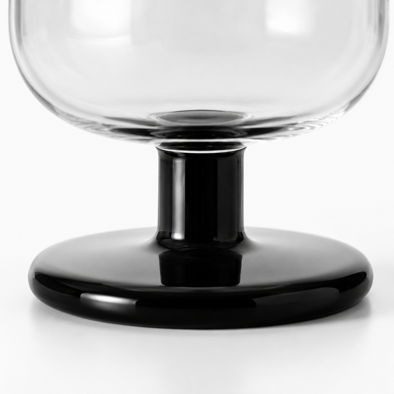 Clear glass bowl with black base on a white background