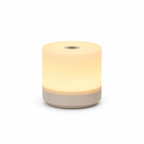 Round night light with a beige base and yellowish-white glow on a white background