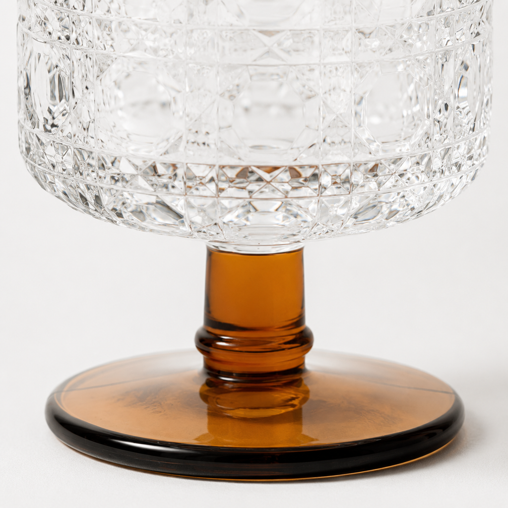 Crystal wine glass with an amber base on a white background