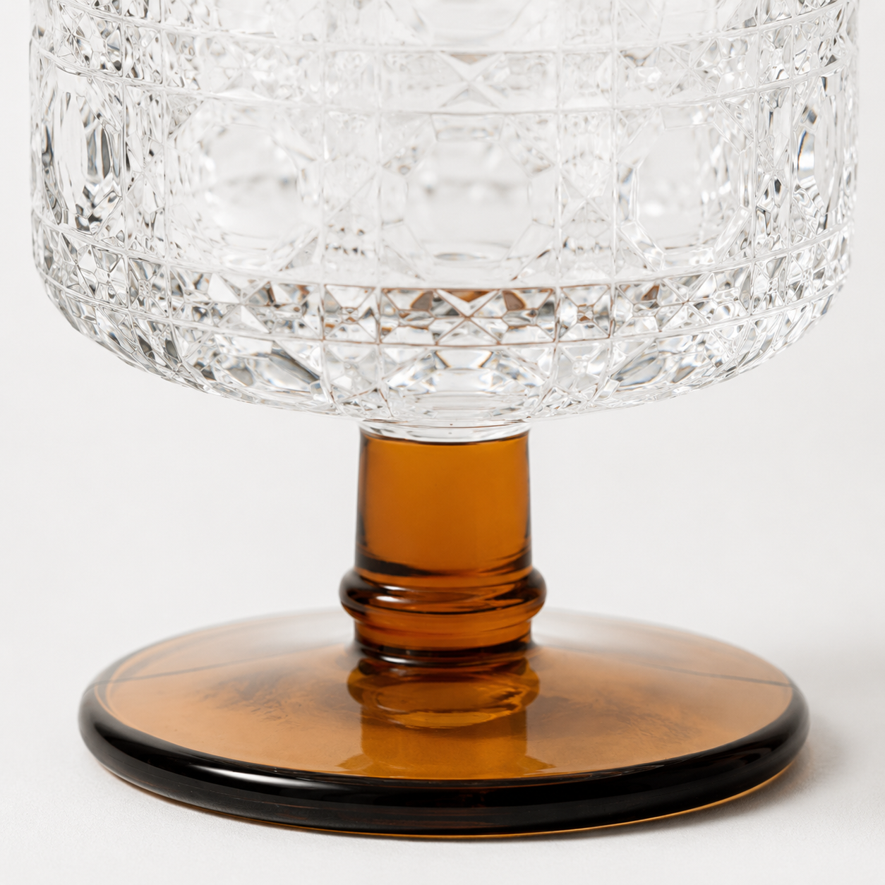 Crystal wine glass with an amber base on a white background