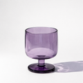 Purple glass with a stem on a white background