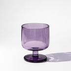 Purple glass with a stem on a white background
