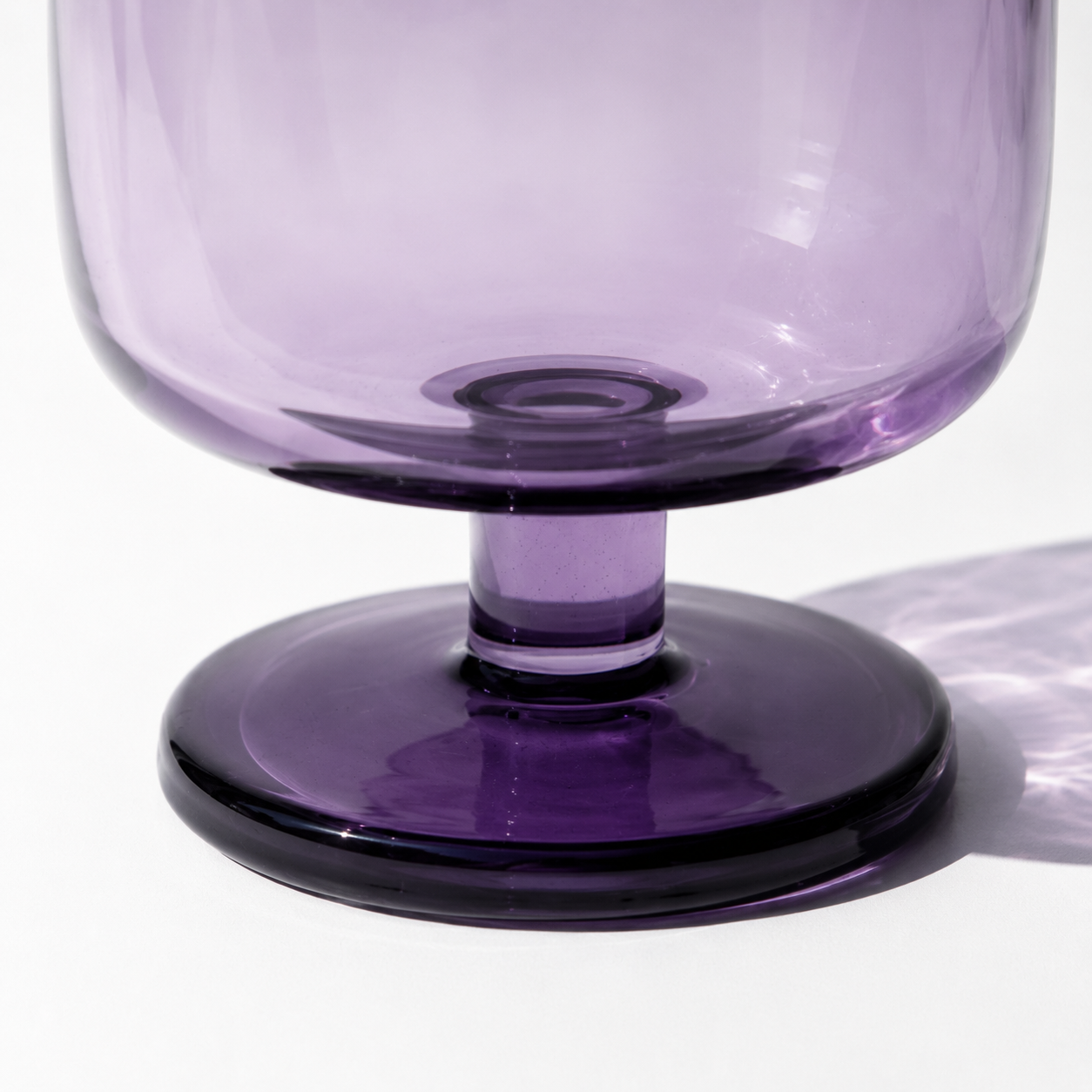 Close-up of a purple glass with a stem on a white background