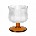 Clear glass bowl with ribbed design and amber base on a white background