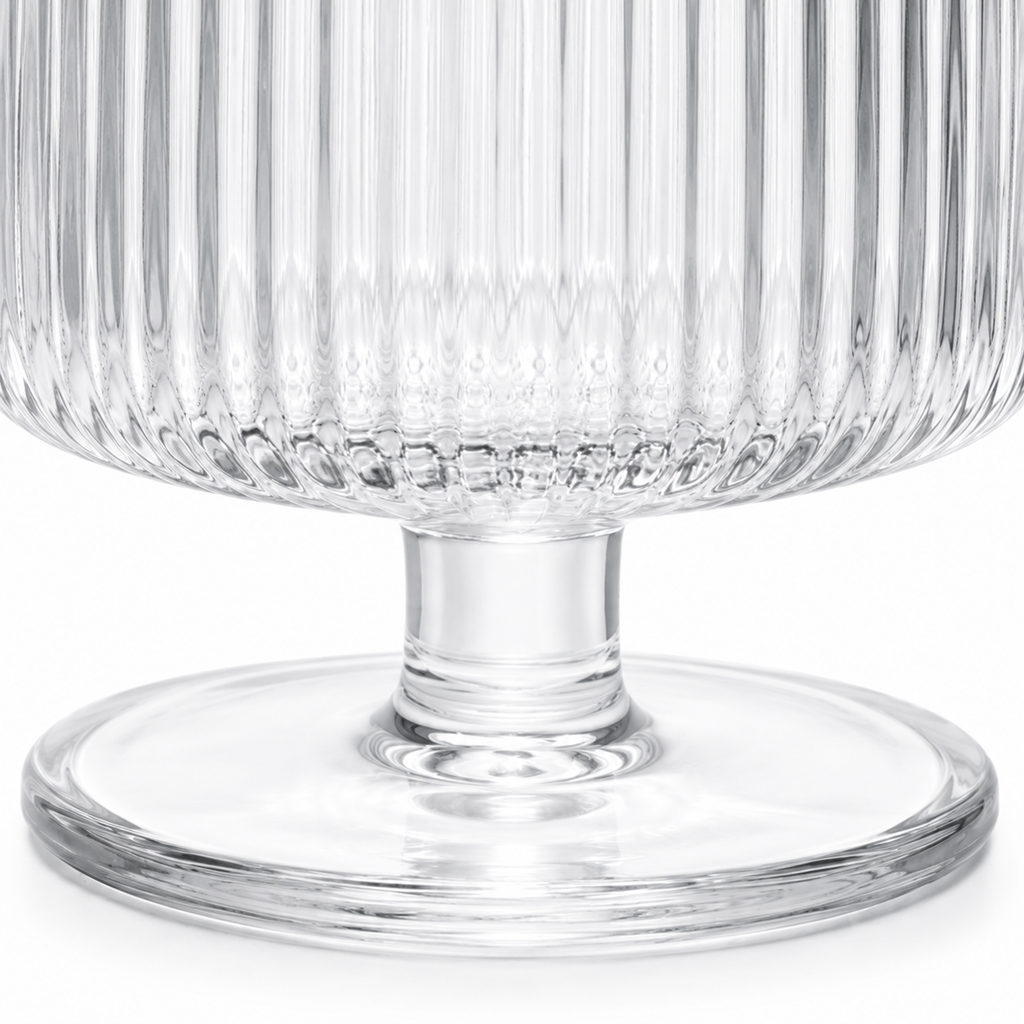 Clear glass pedestal bowl with textured design on a white background