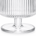 Clear glass pedestal bowl with textured design on a white background