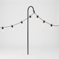 String of lights with a black metal stand on a light gray background