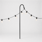 String of lights with a black metal stand on a light gray background