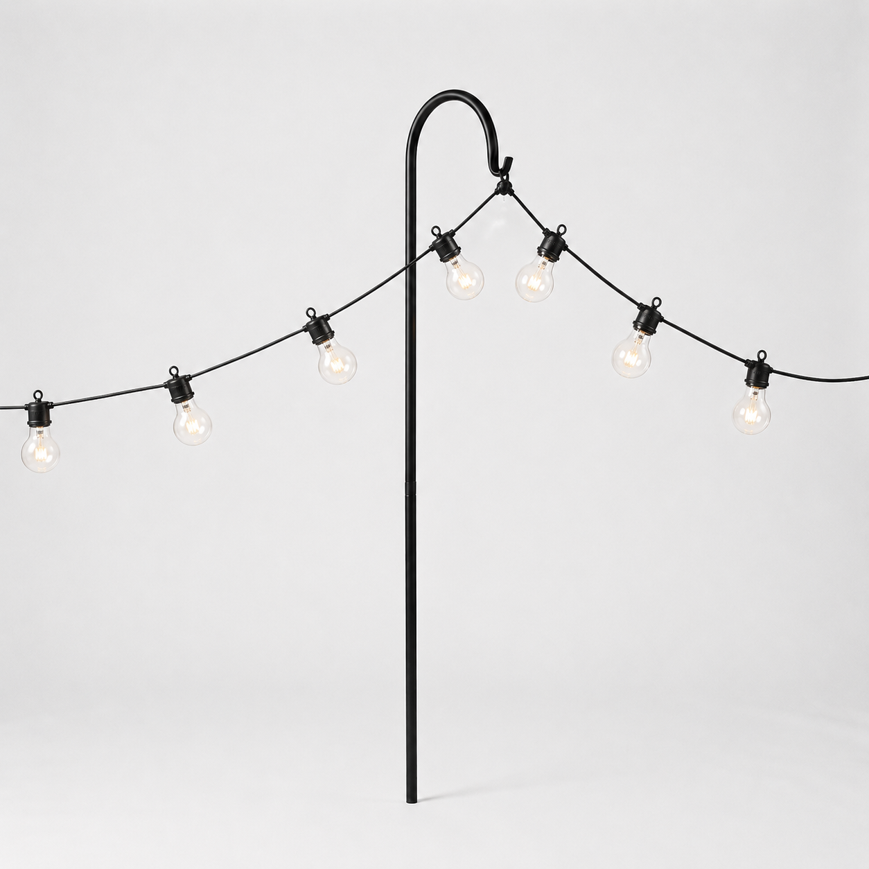String of lights with a black metal stand on a light gray background