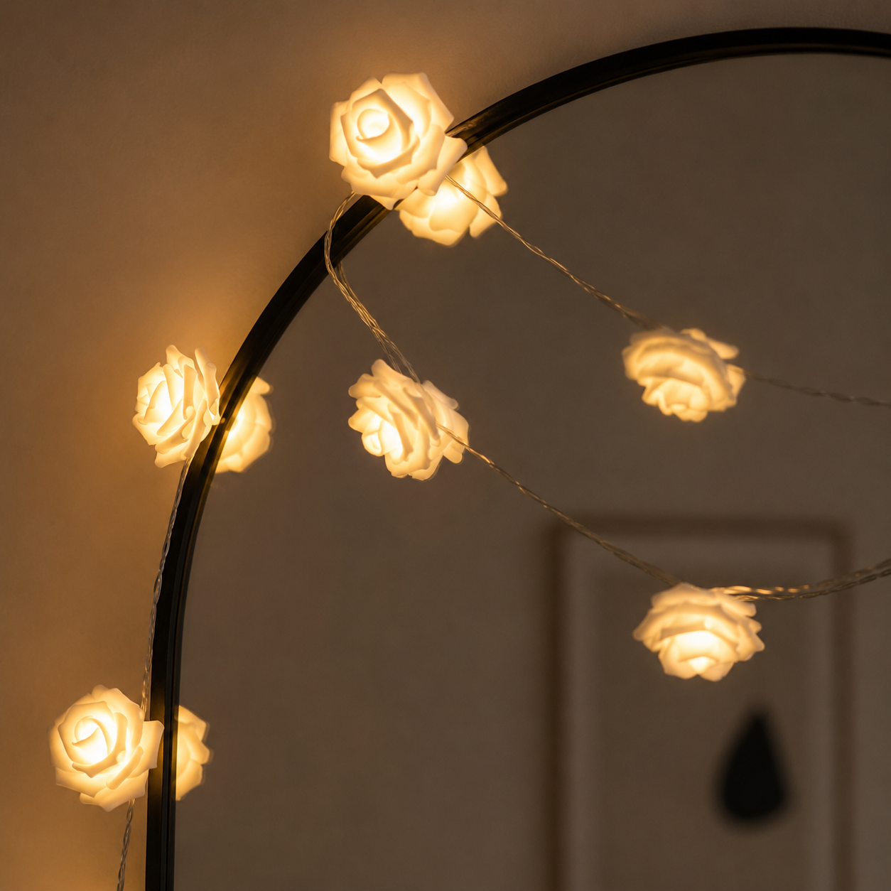 String of rose-shaped lights on a black metal arch against a dark background