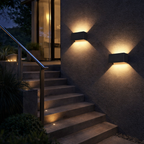 Outdoor staircase with wall-mounted lights illuminating the steps at night.