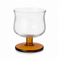 Clear glass candle holder with amber base on a white background
