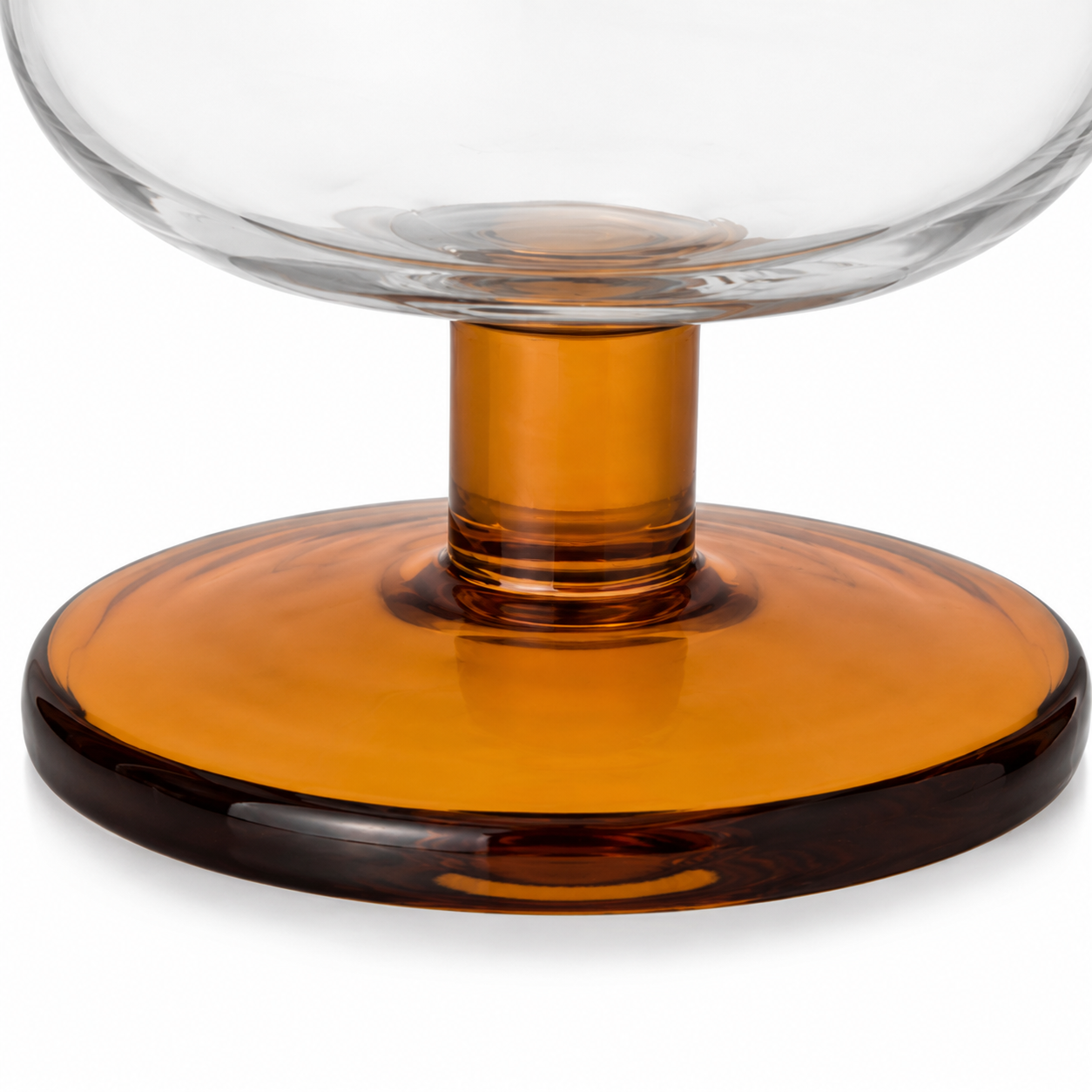 Glass object with a clear top and amber base on a white background